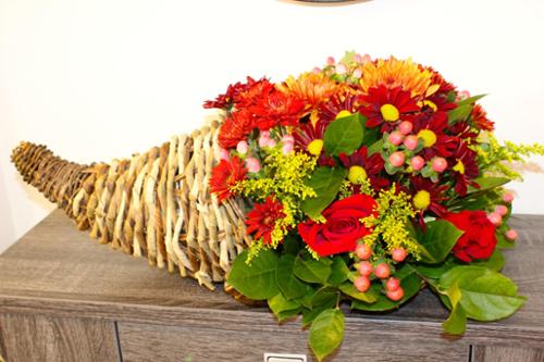 A combination of roses and mums in fall colors, arranged in a 12" fern cornucopia. This arrangement can be used as a centerpiece or a decor to create a classic Thanksgiving vibe.